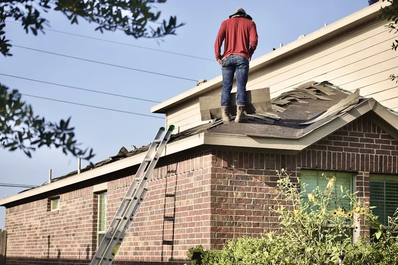 Professional roofer working on a residential roof in Audubon Circle